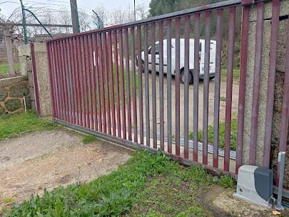 Portão de correr vermelho com motor de automatismo visível